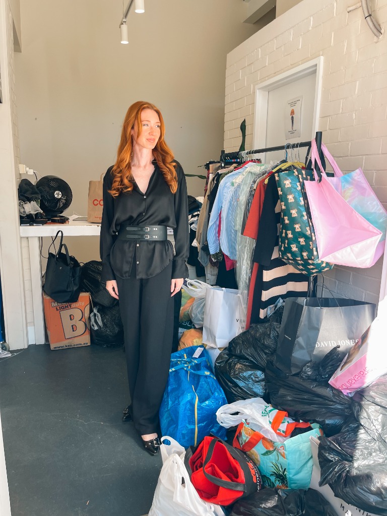 Rachel Gallagher with donated garments for the Connected by Clothes clothing drive supporting Dress for Success